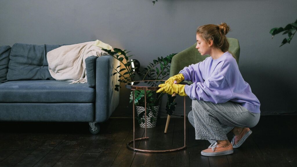 Female cleaning stylish living room in apartment
