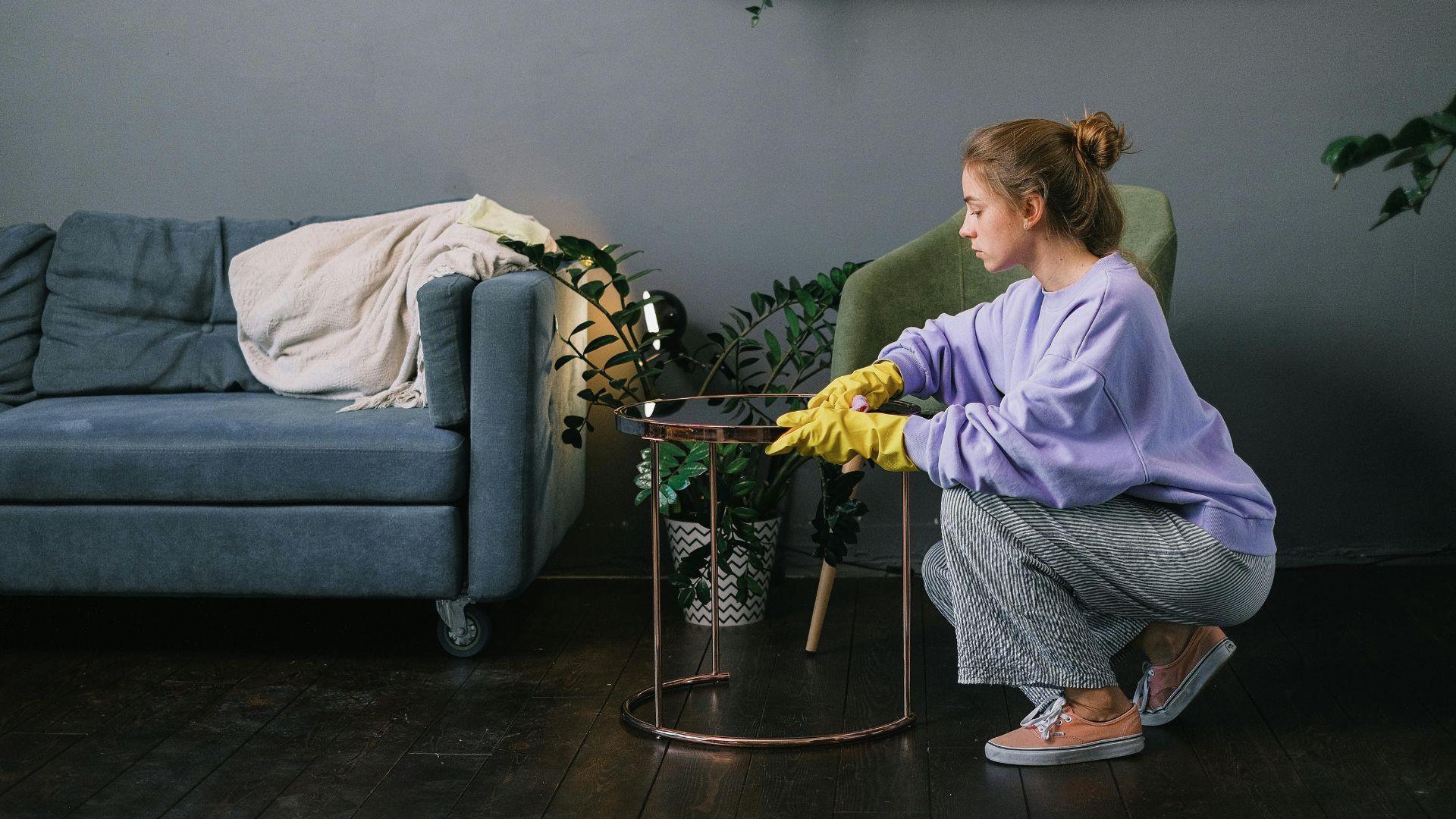 Female cleaning stylish living room in apartment